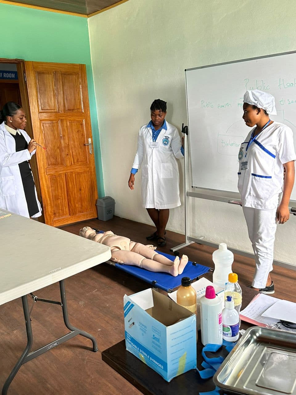 Students practising emergency response with a training mannequin