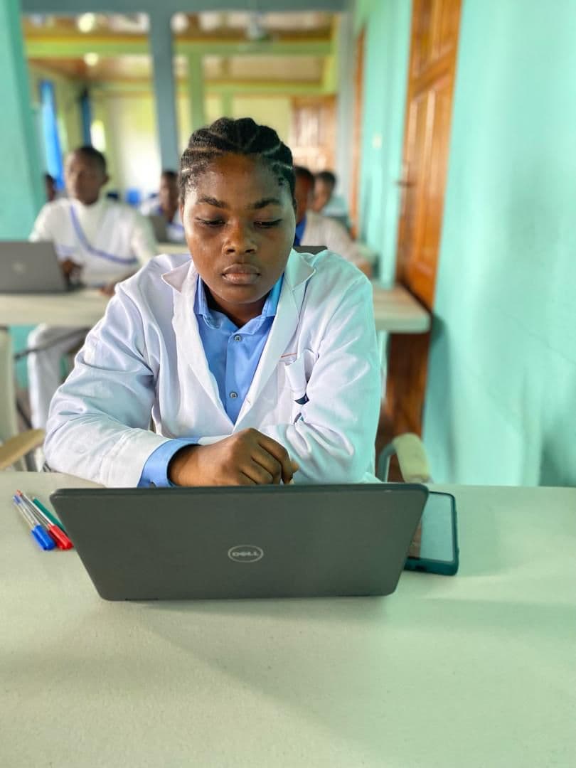 Student studying on a laptop in class
